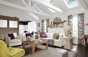 Beyond Just “Natural Light”: The New Engineering Standard for Home Skylights - Intrepid Builders LLC. Bright, airy living room with white sofas, purple cushions, a wooden coffee table, and skylights above.
